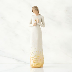 Brunette girl figurine in white dress holding white candle in one hand