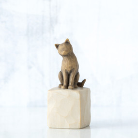 Golden cat figurine sitting on white rock