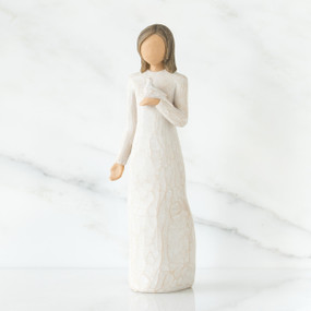 Woman figurine with brown hair in white dress holding white dove