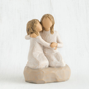 Two blonde faceless girls wearing white dresses hugging another on rock figurine