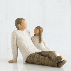 Man figurine and daughter faceless figurines sitting looking at one another - wearing white shirts and brown pants