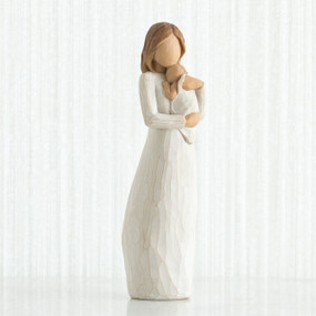 Faceless mother figurine wearing white dress holding baby to her neck
