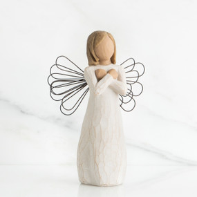 Young girl faceless angel figurine wearing white dress, black wire wings, and holding arms to her chest