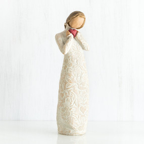 Standing faceless woman figurine in white dress facing forward holding pink heart