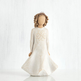 Faceless girl figurine with brown curly hair wearing white dress facing forward