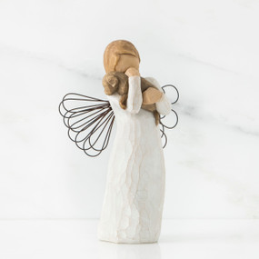 Angel figurine faceless holding brown puppy to her face - wings are wire
