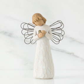 Small girl figurine with blonde hair wearing white dress and holding light grey animal - she has black wire wings