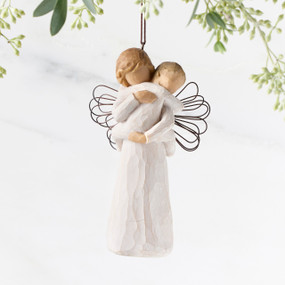 Figure of female in cream dress with wire wings, holding baby in cream onesie, with ornament loop on head