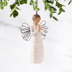 Female figure with wire wings in cream dress carved with a tree design, holding hands in prayer, ornament loop attached to head