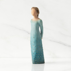 Front/left view: Lighter-skin figure, arms clasped behind back, hair and deep blue ombré garment dotted with gold leaf
