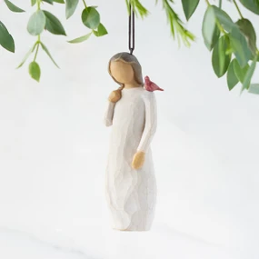 Front view of figure in cream dress with cardinal red bird perched on shoulder, hook & loop in head