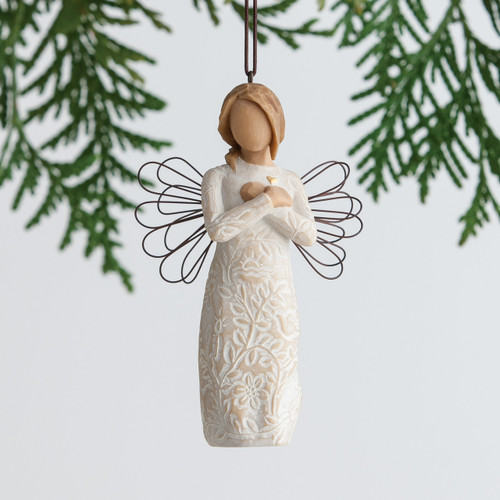 Hanging angel figurine ornament from green branches in white dress with black wire wings