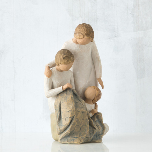 Brother and sister figurine sitting around small sister figurine - all faceless, wearing white