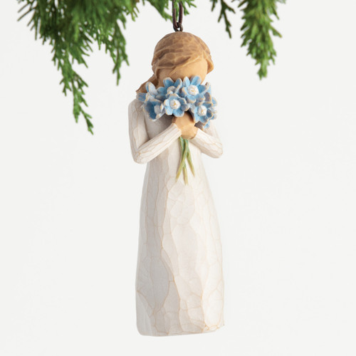 Front view, female figure in cream dress, holding bouquet of blue forget-me-not flowers to face. Hook and loop affixed to head