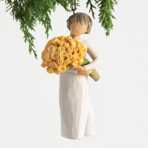 Front view, female figurine in cream dress, holding large bouquet of yellow roses. Hook and loop affixed to figure's head