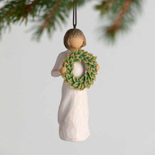 Front view, female figure in cream dress, holding green wreath of magnolia leaves. Hook and loop affixed to figure's head