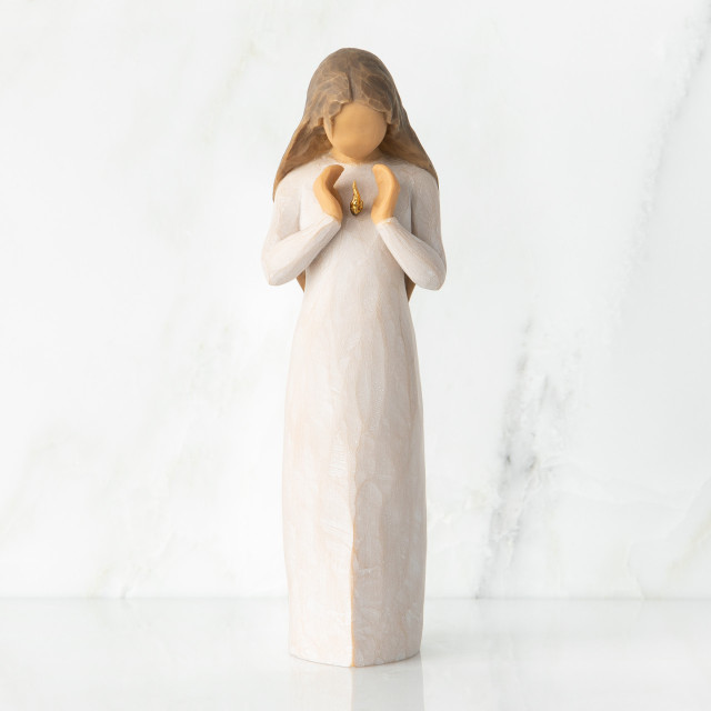 Front view, standing female figure in cream dress, hands surrounding small gold-leaf flame on chest