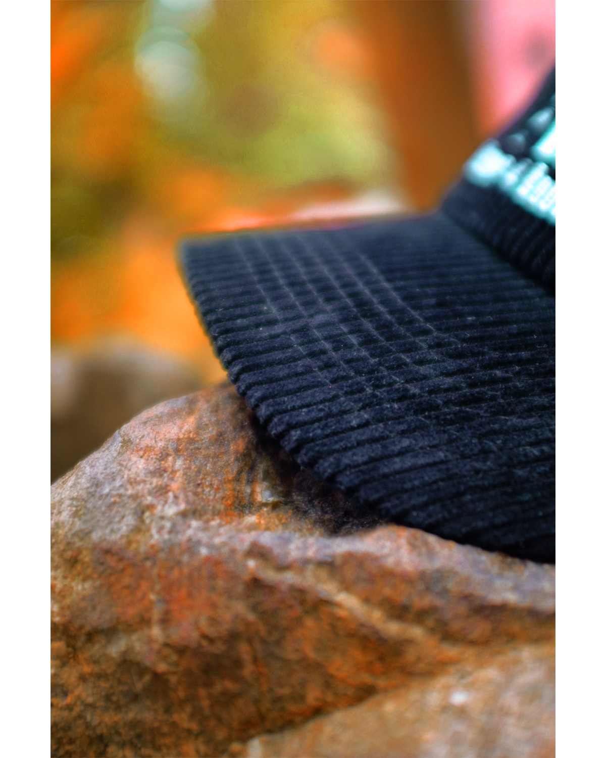 A black corduroy hat with the OR Books logo and 'Money 4 Books' written under it, placed on a fire hydrant