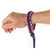 Dark blue and pink braided paracord bracelet on wrist, shown close up.