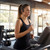 Woman in black sports vest running on treadmill in gym