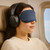 Black over-ear headphones worn by passenger on plane seat