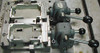 Two 2-FLs with fixturing, closed on two parts. Notice the contact dowels on the left side of the block at the end of the center bar. The part (casting) has a slight burr around its edge.