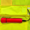 Folded high-visibility police vest featuring reflective mesh fabric and detachable rechargeable battery pack for powering LED illumination in low-light working environments.