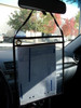 Black work order holder hanging from rearview mirror