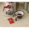 Folgers Classic Roast coffee portion pack next to drip coffee maker and filter