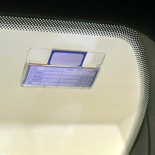 Standard service record card, shown inserted into plastic card holder, attached to upper  corner of car windshield