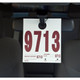 White service hang tag with red print hangs from car rearview mirror