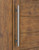 Pro-Line Series: Grooved Ladder Pull Handle - Back-to-Back, Brushed Satin US32D/630 Finish, 304 Grade Stainless Steel Alloy mockup on wood door