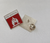 This small red and silver "Fire Marshal" badge measures 2.5x2.5cm and features a clear flame symbol. It is designed to be worn by fire marshals to visually identify them in the workplace or during emergencies. The badge includes the text "Fire Marshal" above the flame icon, allowing for easy identification of personnel responsible for fire safety duties. This durable badge is suitable for secure attachment to uniforms or clothing, aiding in the quick location of fire marshals during critical situations.