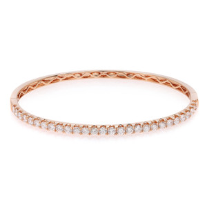 An image of a Rachel Koen women's bracelet with diamonds, displayed in a close-up, centered view against a white background. The bracelet is oriented horizontally across the frame, showcasing its full circle with a rose gold band and a single row of sparkling round cut diamonds along the top visible surface. Carved details are visible on the inner side of the band, demonstrating the intricate design. The perspective is head-on, allowing the diamonds to catch the light and exhibit their brilliance.