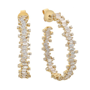 An image of a pair of Rachel Koen women's hoop earrings with diamonds, displayed on a white background. The earrings are presented in a front-facing view, symmetrically positioned side by side, with a slight angle that allows the depth and design of the baguette and round-cut diamonds to be visible in yellow gold. The earrings are positioned in a close-up perspective that emphasizes the sparkle and intricate setting of the diamonds.