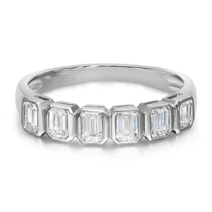 An image of a Rachel Koen women's ring with diamonds, positioned centrally and viewed from a slight top angle to showcase its design. The ring features a polished white gold band with evenly spaced emerald-cut diamonds encircling its entirety, captured from a close-up distance to highlight the gemstones' clarity and the ring's elegant setting.