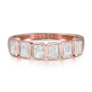 An image of a Rachel Koen women's ring with diamonds, displayed in a close-up, front-on view. The ring features a polished rose gold band with a series of evenly spaced, emerald-cut diamonds. The craftsmanship highlights the clarity and brilliance of the diamonds, and the rosy hue of the band complements their sparkle. The image is taken at a slight angle to show the ring's profile and the setting of the stones, against a neutral, light background.
