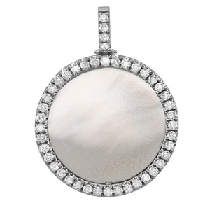 An image of a men's Rachel Koen brand pendant with diamonds, shown from a frontal view at a close distance. The pendant features a large, circular design with a smooth, metallic photo center that has a frosted appearance. The pendant is encircled by a halo of round-cut diamonds set in white gold, creating a sparkling border. The diamond setting is visible, and each stone catches the light differently, indicating their faceted nature. The pendant is attached to a matching white gold bail comprised of a single column of smaller diamonds, suggesting that it would hang vertically from a chain. The background is a pure white, emphasizing the contrast and details of the necklace.