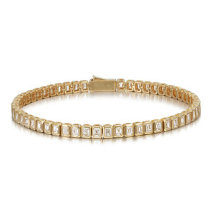 An image of a Rachel Koen unisex adult tennis bracelet with diamonds, positioned front and center against a white background. The bracelet is displayed at a slight angle, showcasing its full circle with a visible clasp at the top. The emerald cut  diamonds are set in a bezel setting that wraps around the entirety of the bracelet, glistening against the yellow gold setting. The piece is photographed from a medium distance, allowing clear visibility of the diamonds' cut and the bracelet's design.