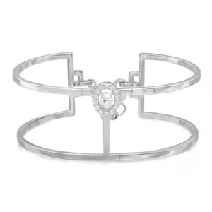An image of a Messika women's Manch Glam'Azone 2 row 18k white gold bracelet with diamonds, shown in a frontal view against a white background. The bracelet features a symmetrical open cuff design with a prominent diamond centerpiece surrounded by a halo of smaller diamonds. The bracelet's bands extend horizontally from the centerpiece and are visible in full, illustrating the sleek and elegant design.