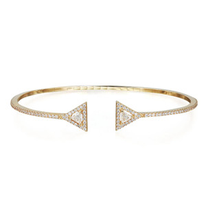 An image of a women's Messika Skinny Thea Diamond open 18k yellow gold bracelet with diamonds, presented on a white background. The bracelet is shown in a frontal view with a slight angle, highlighting its open cuff design and triangular diamond-encrusted details at each end. It is positioned centrally in the frame, allowing a clear view of the piece from a medium distance. The bracelet's band is slim and encrusted with smaller diamonds, complementing the two larger, triangle-shaped features. 