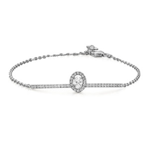 An image of a Messika women's Glam'Azone chain 18k white gold bracelet with diamonds, displayed against a white background. The bracelet is positioned in a straight horizontal line with the central diamond feature prominently in the center. The bracelet's chain has a delicate, linked design, and the central diamond is encircled by a halo of smaller diamonds. The image is taken from a top view at a close distance, ensuring the intricate details of the diamonds and the craftsmanship of the bracelet are clearly visible.