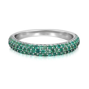 An image of a Rachel Koen brand women's ring with emerald gemstones, presented in a close-up side view that showcases the full circle of the band. The ring features a multitude of small, round, green emerald gemstones set in a dense, pavé style along the top half, with the stones catching the light at various angles. The band is made of a polished white gold, visible on the lower half, and reflects a soft gleam. The background is a plain white, emphasizing the ring's colors and intricate gemstone setting.