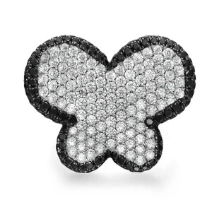 An image of a Rachel Koen women's cocktail ring with diamonds, showcasing a butterfly-shaped top view. The ring is centered and photographed from a top-down angle, providing a clear, close-up view of the intricate design. The butterfly motif is adorned with a dense pavé of sparkling white diamonds, contrasted by a border of smaller black diamonds outlining the wings, all set on a polished white gold band. The image captures the ring's luxurious and detailed craftsmanship.