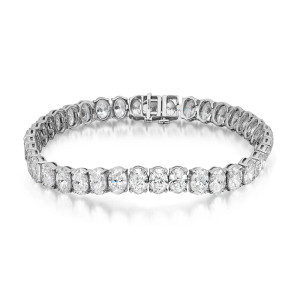 An image of a Rachel Koen brand unisex adult tennis bracelet with lab grown diamonds, positioned centrally and photographed from a top-down angle. The bracelet is displayed against a white background, with a slight shadow underlining its form. It features a continuous row of large, round-cut diamonds, each encased in prong setting in white gold that contributes to the overall elegant design. The clasp of the bracelet is visible and securely fastened. The photo is taken from a close distance, showcasing the brilliance and clarity of the diamonds.