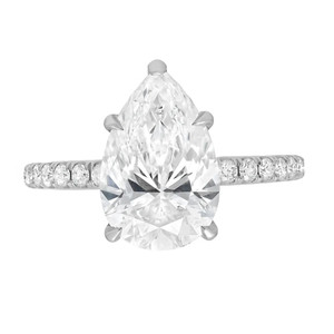 An image of a Rachel Koen women's engagement ring with lab grown diamonds, showcasing a prominent pear-shaped central diamond in a prong setting. The ring is viewed from a top-down angle, centered and in close proximity, allowing clear visibility of the diamond's facets and the band's prong set round lab grown diamonds. The white gold metal setting provides a stark contrast to the sparkling stones, emphasizing the ring's elegance and craftsmanship.