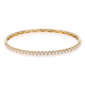 An image of a Rachel Koen women's bracelet with diamonds, displayed in a close-up frontal view on a white background. The bracelet has a circular shape and is oriented horizontally across the frame, showcasing a row of sparkling diamonds set in a polished yellow gold band with intricate detailing visible on the inner side. The piece is shown in sharp focus, capturing the brilliance of the diamonds and the craftsmanship of the design.