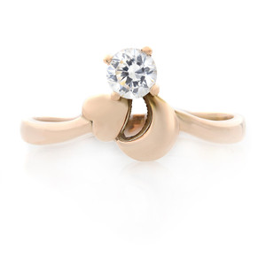 An image of a Rachel Koen women's ring with cubic zirconia, displayed at a slight left angle showing the band and setting. The ring features a prominent solitaire cubic zirconia held by four prongs atop a smooth, polished 14K rose gold band, with the camera positioned at a close distance to capture the sparkle and detail. The ring is pre-owned in a great condition. 