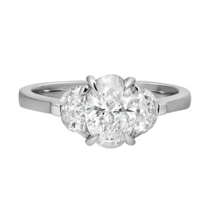 An image of a Rachel Koen women's engagement ring with lab grown diamonds, showcasing a front-facing view with the band horizontally oriented. The ring features a prominent centre round-cut lab grown diamond flanked by two smaller round-cut lab grown diamonds, all held in place by prong settings. The diamonds are positioned closely together, creating a sparkling focal point. The smooth, polished band subtly tapers towards the stones. The image is taken from a close-up angle, emphasizing the clarity and brilliance of the diamonds.