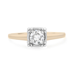An image of a Rachel Koen brand women's antique engagement ring with diamond, featuring a centrally mounted round-cut diamond in a prong setting. The ring is presented at a straight-on angle, centered in the frame, with a close-up view that focuses on the diamond and the upper portion of the gold band. The background is a neutral white, emphasizing the contrast and details of the ring's design. The ring is pre-owned in great condition. 